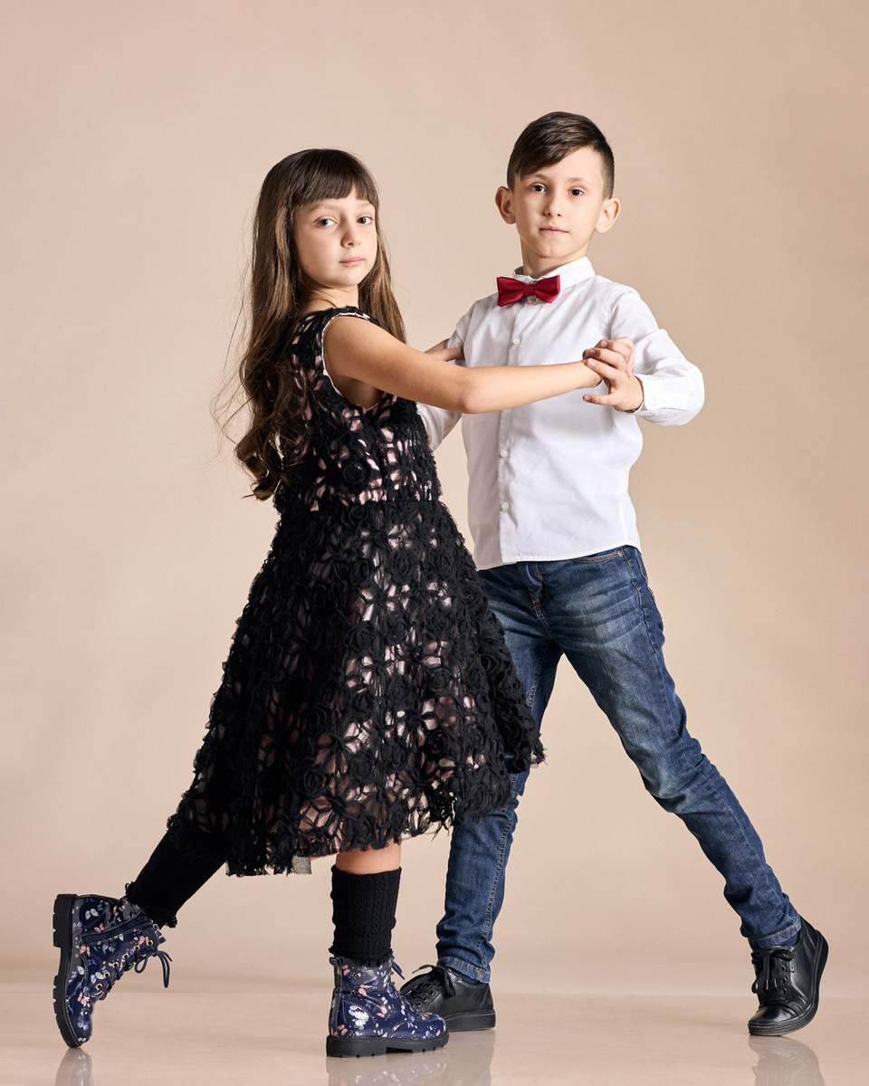 Two children, a boy and a girl, posing in a dance move